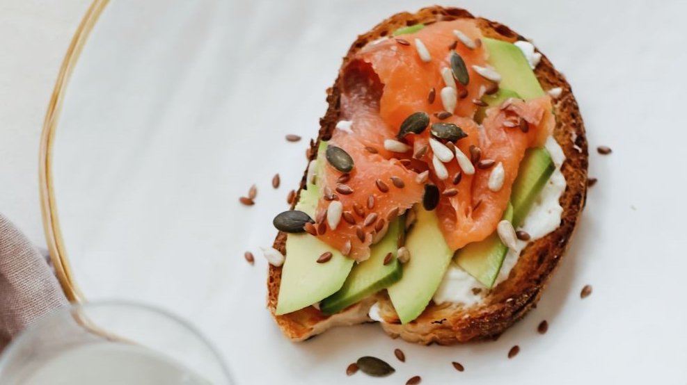 Zu sehen ein Teller mit ein belegten Lachs-Avocado Brot.